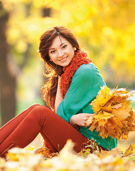 A photo of a woman sitting among some leaves