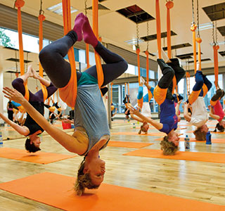 Some people in an anti-gravity yoga class