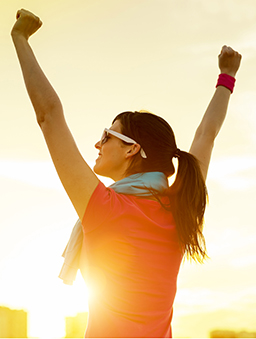 A photo of a woman with arms raised triumphantly