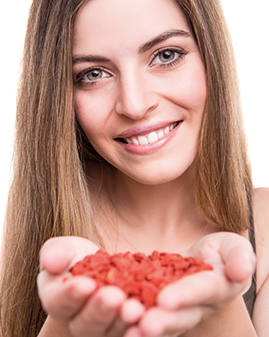 A photo of a woman holding goji berries