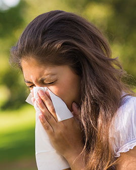 A photo of a woman sneezing