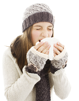 A woman sneezing into a handkerchief