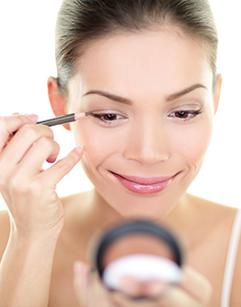 A photo of a woman putting on make-up