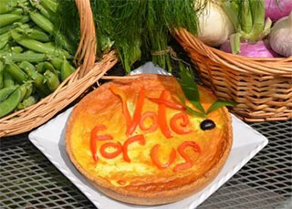 A photo of a pie with vote for me made from vegetables
